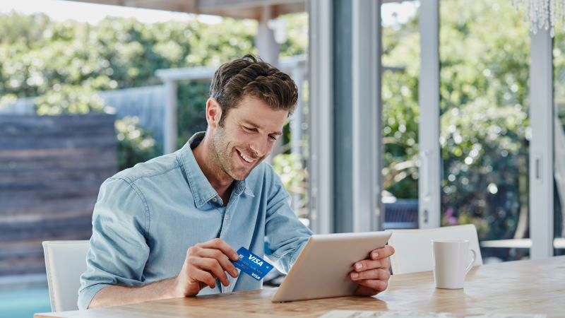 Man with card looking at tablet